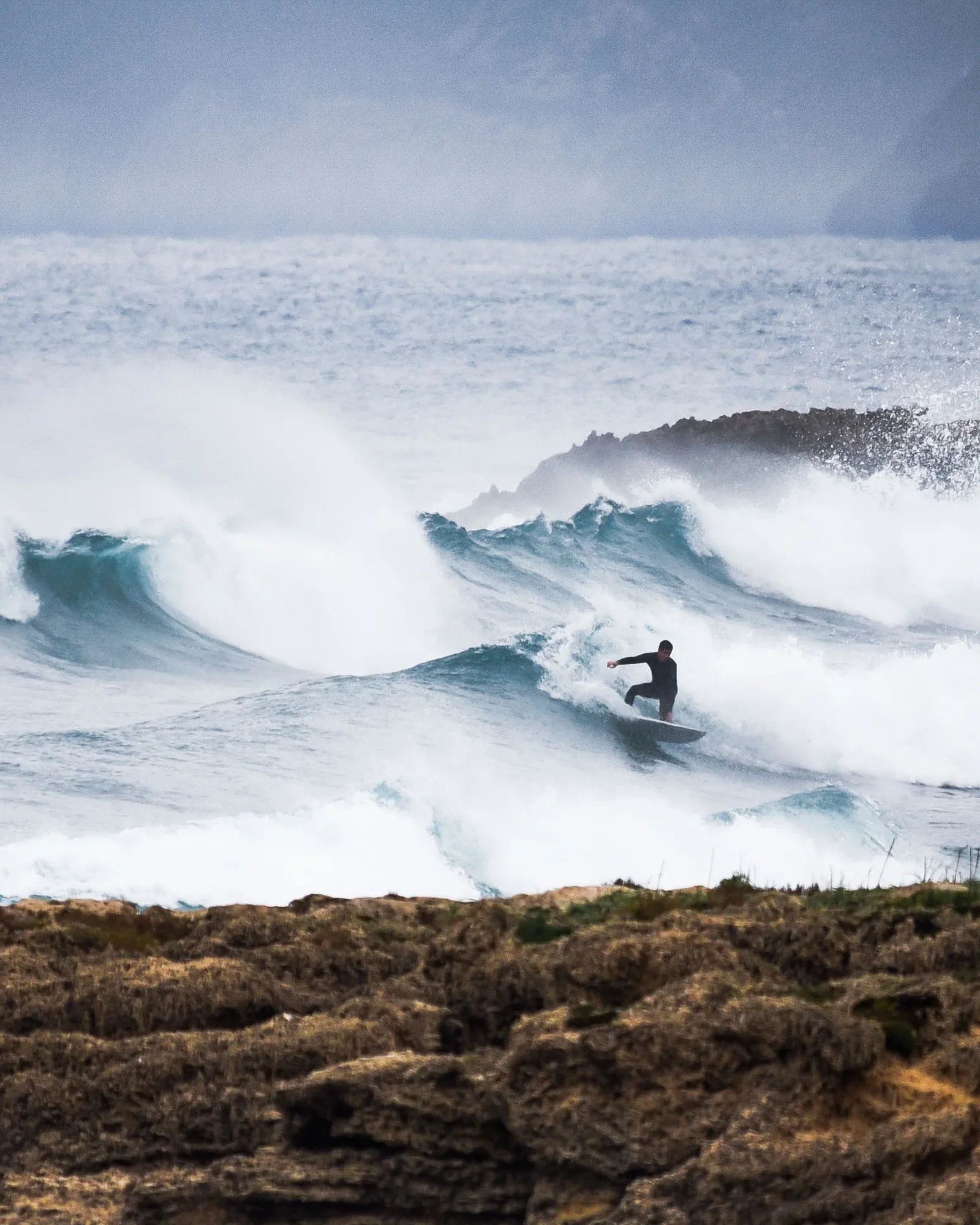 Surfista tra le onde ripreso dalla costa